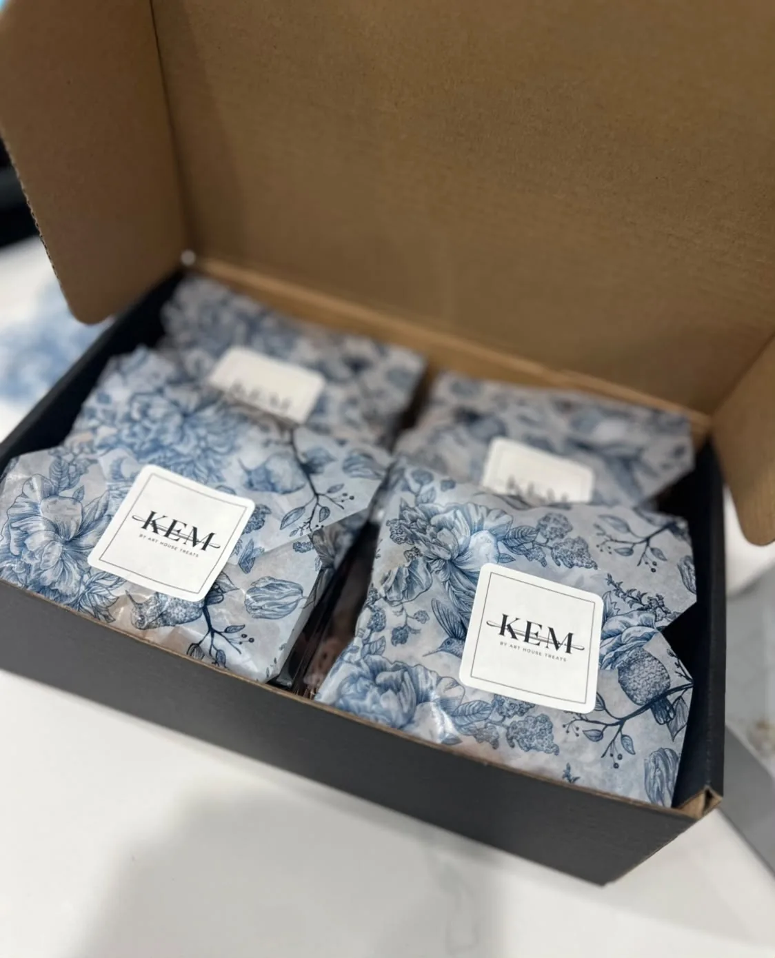 A KEM gift box, each parcel wrapped in blue toile paper and sealed with a KEM label